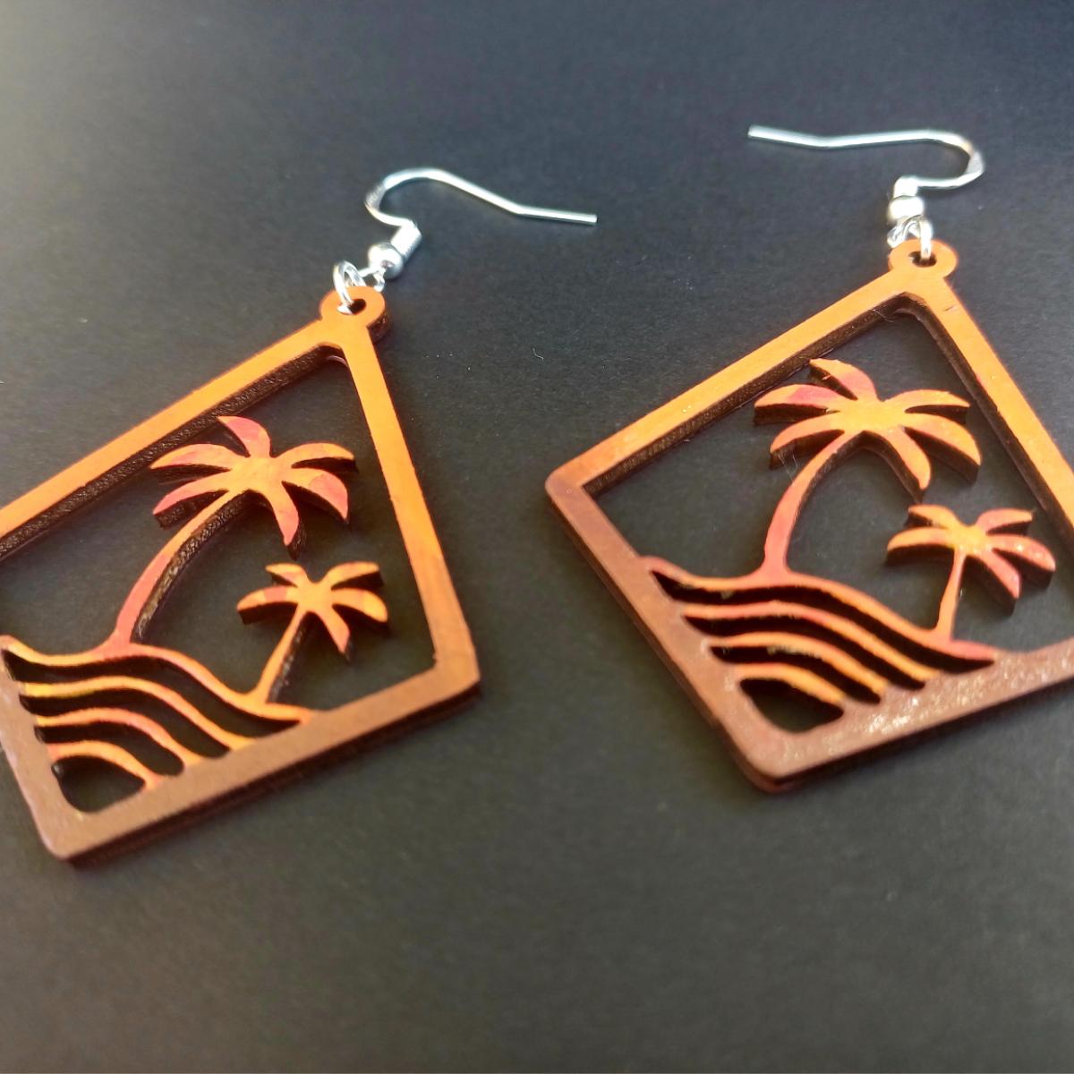 Boucles d'oreilles pendantes en bois en forme de losange ajouré avec motif de palmiers et vagues en dégradé rouge, orange, jaune
