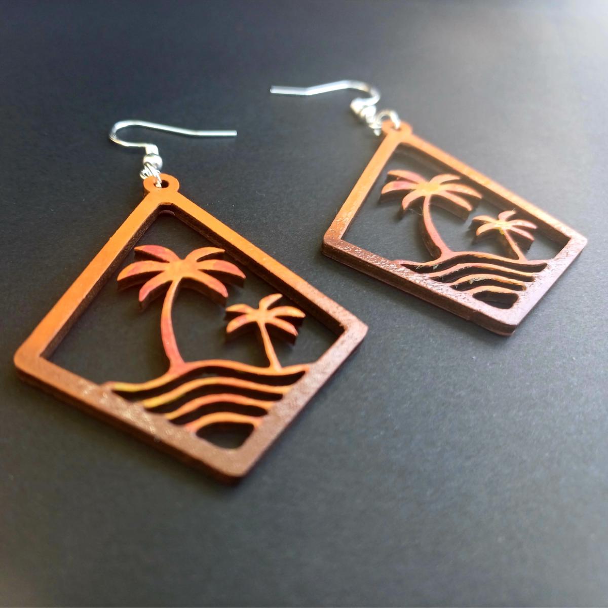 Boucles d'oreilles pendantes en bois en forme de losange ajouré avec motif de palmiers et vagues en dégradé rouge, orange, jaune
