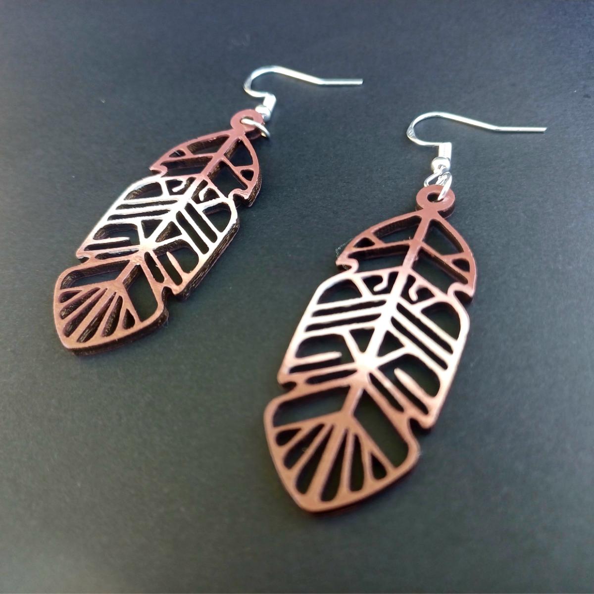 Boucles d'oreilles pendantes en bois ajouré en forme de plume de couleur marron avec crochets argentés hypoallergéniques