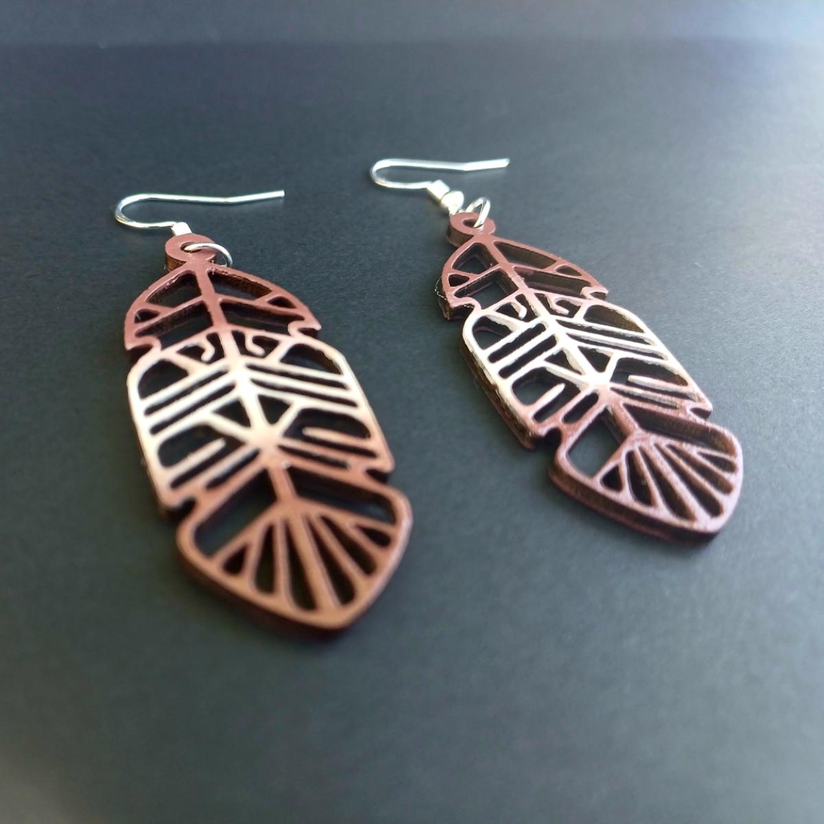Boucles d'oreilles pendantes en bois ajouré en forme de plume de couleur marron avec crochets argentés hypoallergéniques