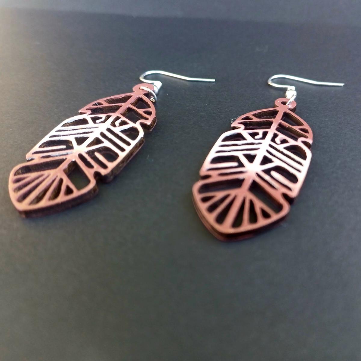 Boucles d'oreilles pendantes en bois ajouré en forme de plume de couleur marron avec crochets argentés hypoallergéniques