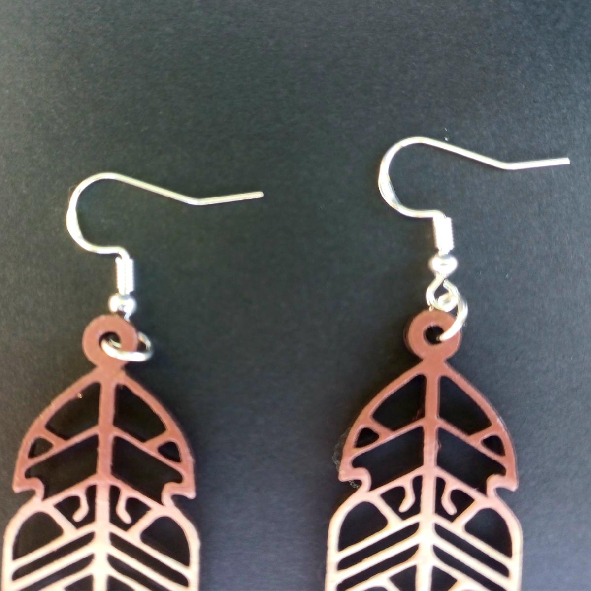 Boucles d'oreilles pendantes en bois ajouré en forme de plume de couleur marron avec crochets argentés hypoallergéniques