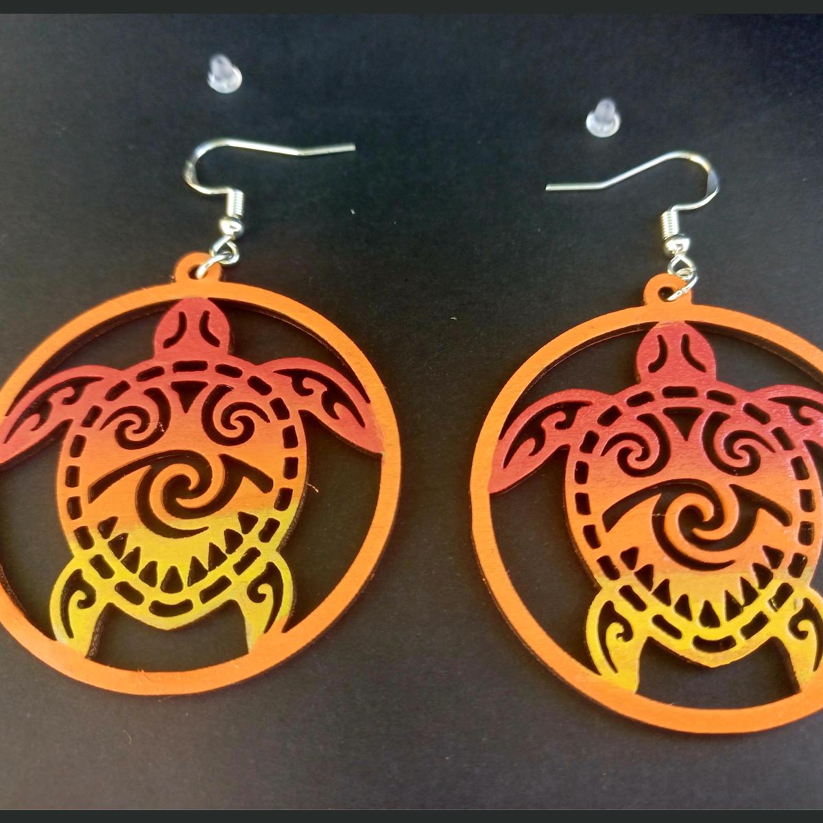 Boucles d'oreilles pendantes rondes en bois ajouré avec motif de tortue tribale en dégradé rouge, orange et jaune et bouchons silicone