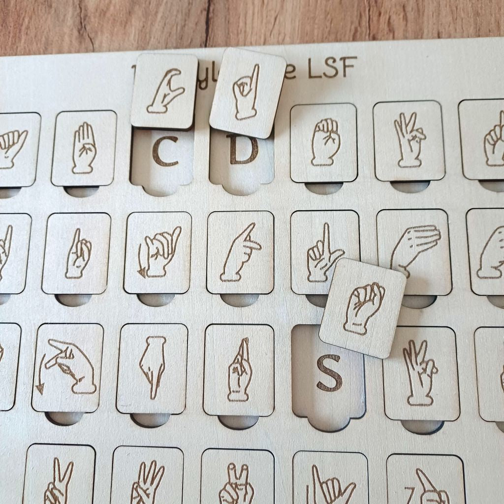Gros plan sur les gravures des mains en langue des signes française sur jetons en bois