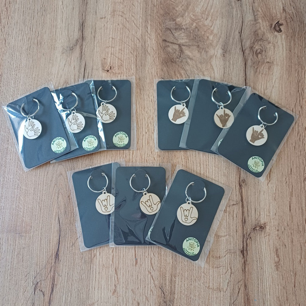 Mini porte-clés ronds en bois gravés en Langue des Signes LSF mis sur cartonnette noire et sous blister